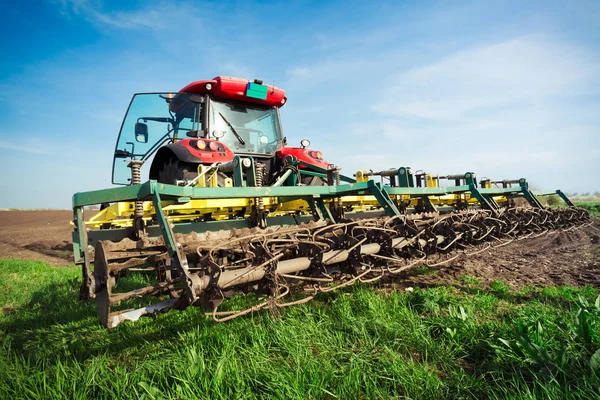 Farmář v traktor příprava půdy s Záhonový kultivátor v earl — Stock fotografie
