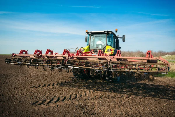 Jordbrukare i traktor förbereder mark med såbäddskultivator — Stockfoto