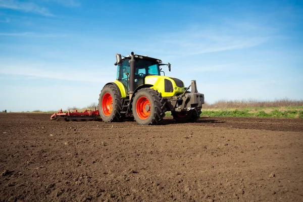 Jordbrukare i traktor förbereder mark med såbäddskultivator — Stockfoto
