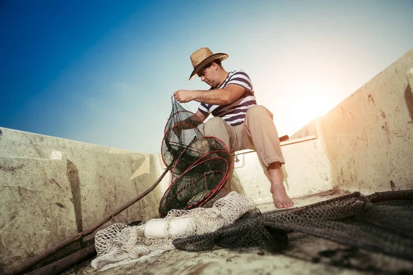 Fisherman checking the net for a catch — Stock Photo, Image