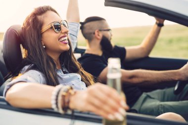 Açık yol özgürlüğü. Genç çift üstü açık araba ülkede yol boyunca sürüş.