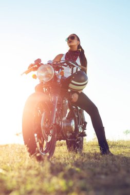 Açık hava yaşam tarzı bir vintage özel motosiklet üzerinde oturan bir genç motorcu Bayan portresi