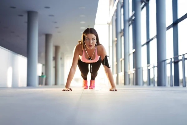 Runner atleet luisteren naar muziek in hoofdtelefoons van slimme telefoon — Stockfoto