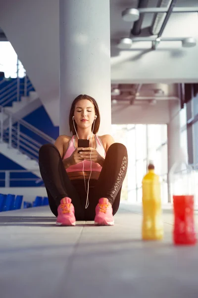 Junge Frau ruht sich nach dem Training im Fitnessstudio aus — Stockfoto