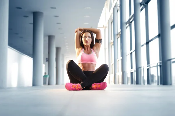 Mujer atlética joven estirándose antes de hacer ejercicio — Foto de Stock