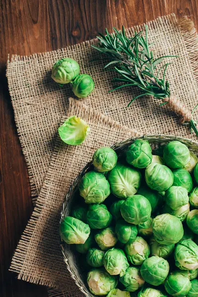 Brussels sprouts in a bowl on an old wooden table — Stock Photo, Image