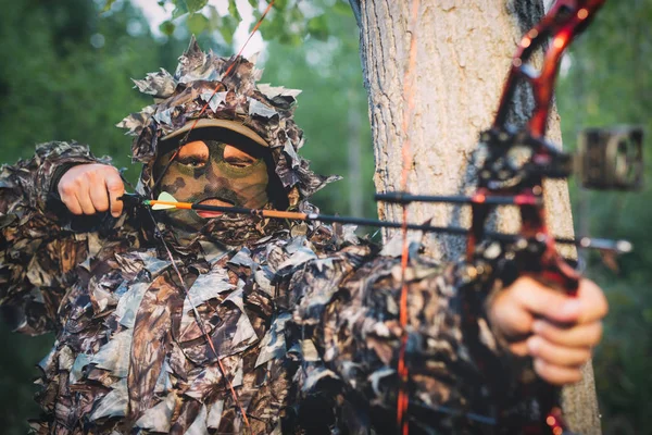 Cazador con arco de caza en el bosque —  Fotos de Stock