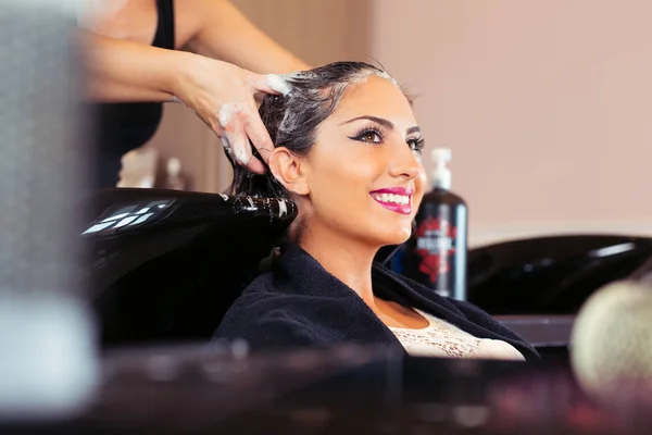 Hermosa joven con cabezal de lavado de peluquería en el salón de belleza — Foto de Stock