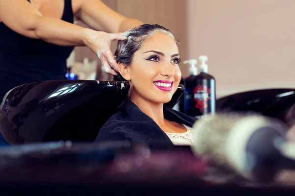 Hermosa joven con cabezal de lavado de peluquería en el salón de belleza — Foto de Stock