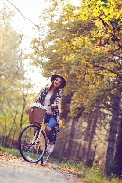 Happy active woman riding bike bicycle in fall autumn park — Stock Photo, Image