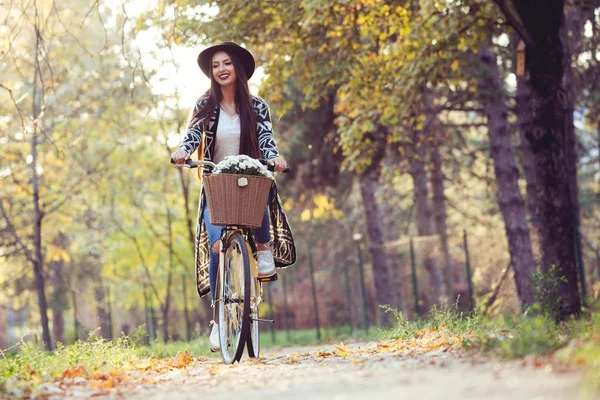 Szczęśliwa kobieta aktywna jazdy na rowerze rower w upadek jesienny park — Zdjęcie stockowe