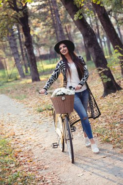 Güzel kadın bir buket ile bir bisiklet içinde açık iterek