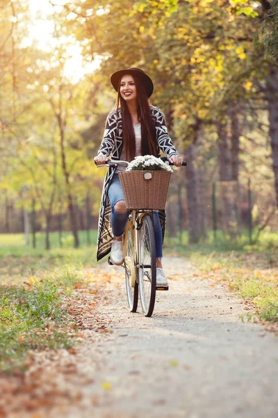 Happy active woman riding bike bicycle in fall autumn park — Stock Photo, Image