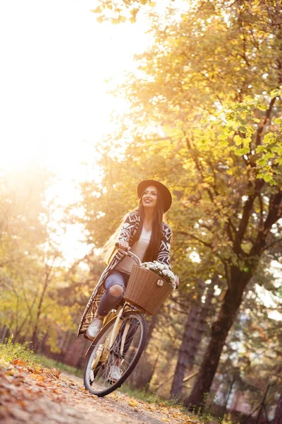 Happy active woman riding bike bicycle in fall autumn park