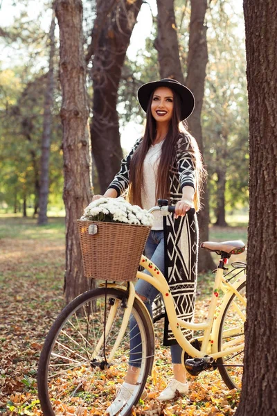 Happy active woman riding bike bicycle in fall autumn park