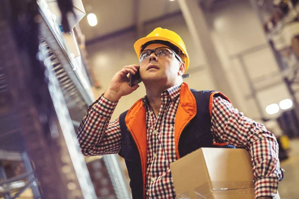 Warehouse worker talking on the phone — Stock Photo, Image