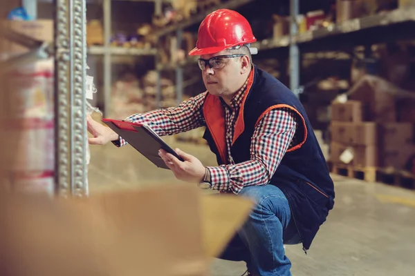 Manager In Warehouse With Clipboard