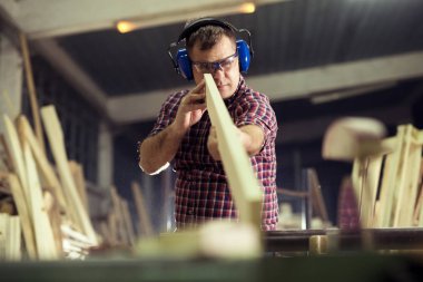 Marangoz marangozluk atölyesinde işini yapıyor.