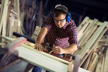 Marangoz marangozluk atölyesinde işini yapıyor.