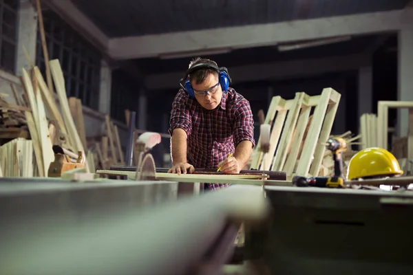 Carpinteiro fazendo seu trabalho na oficina de carpintaria — Fotografia de Stock