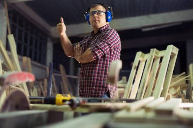 Marangoz marangozluk atölyesinde işini yapıyor.