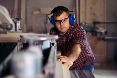 Marangoz marangozluk atölyesinde işini yapıyor.