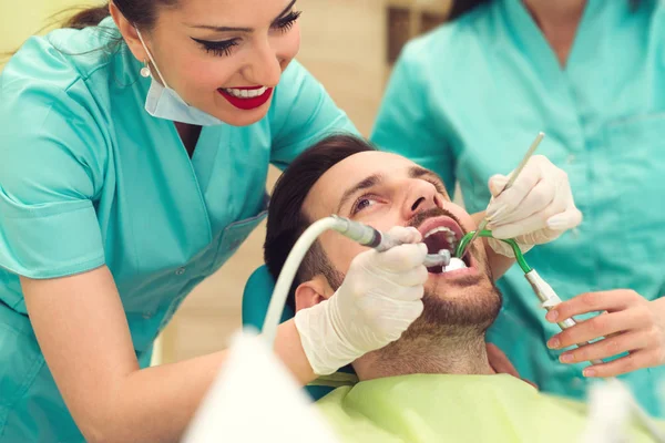 Kvinnliga Tandläkare Undersöker Och Arbetar Ung Manlig Patient Tandläkarpraktik — Stockfoto