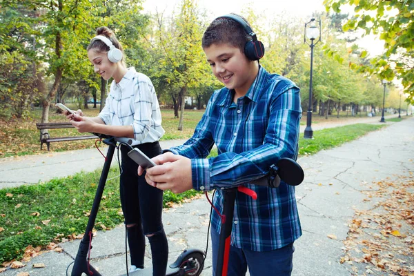 Adolescents Équitation Scooter Avec Leurs Écouteurs Sur — Photo