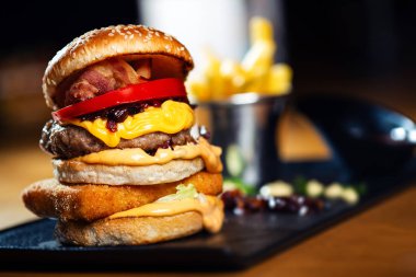 Sığır eti burger peynir ve sebze yakın çekim.