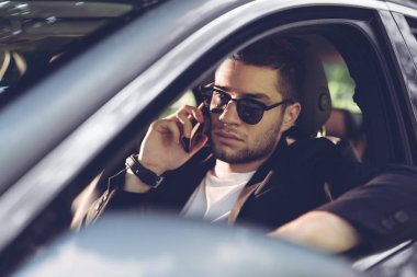 Arabada telefonla konuşan işadamı.