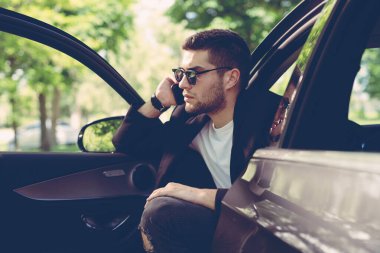 Arabada telefonla konuşan işadamı.