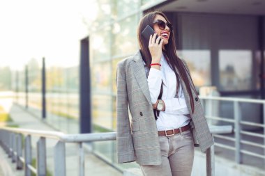 Merdivenlerde tablet bilgisayarlı bir iş kadını oturuyor.