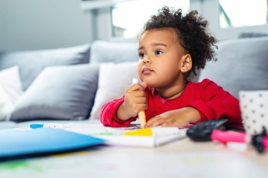 Mutlu Afrikalı Amerikalı anne kızına boyama konusunda yardım ediyor..