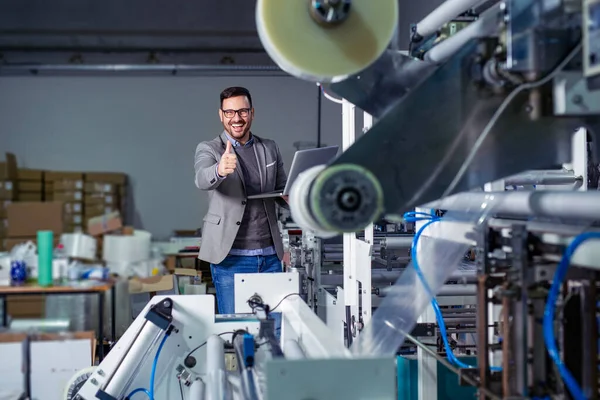 Industrial worker thumb up in factory.   Man in Industrial Environment.