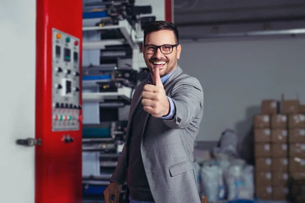 Industrial worker thumb up in factory.   Man in Industrial Environment.