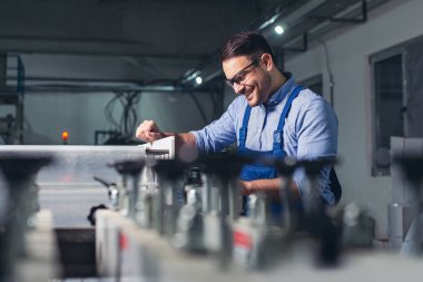 Fabrikada çalışan modern endüstriyel makine operatörü. Makinedeki işçiler