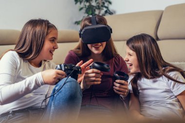 Young girls playing with video games at home.