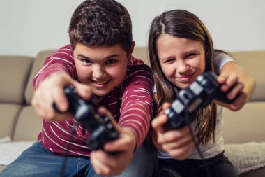 Happy children playing computer games at home