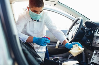 Arabanın içini temizlemek ve dezenfeksiyon sıvısı sıkmak. Covid-19 virüs koronavirüsü enfeksiyonunu önle.