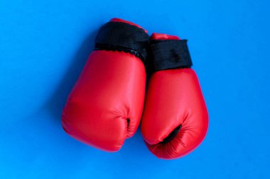 mavi bir arka plan üzerinde kırmızı boks eldivenleri