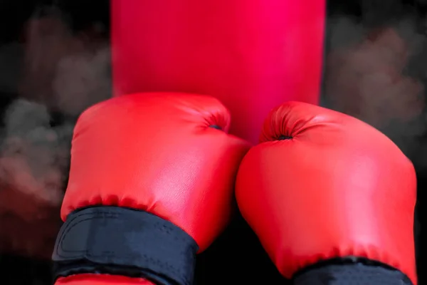 Red boxing gloves hit a boxing bag. Boxer training