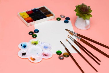 Fırçalar, suluboya, ev bitkisi ve boyamak için boş bir kağıt. Sanat temasının yerleşimi