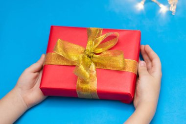 Çocukların elinde hediye olan bir kutu. Altın kurdeleli kırmızı kutu. Yeni yıl hediyesi, Noel hediyesi.. 