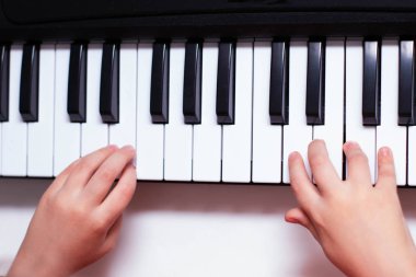 Çocuk elleri piyanonun anahtarlarını çalar. Müzik öğrenme.