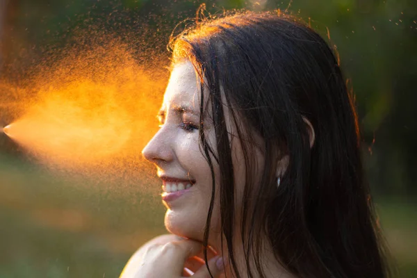 Mulher jovem borrifando água em si mesma de uma garrafa de borrifo, close-up . — Fotografia de Stock