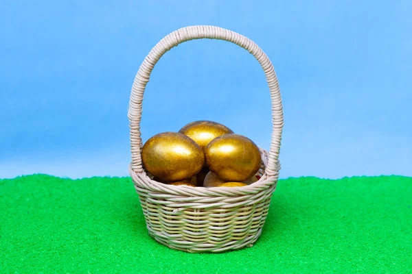 Huevos de oro en una canasta. Para el diseño del tema de Pascua, concepto . — Foto de Stock