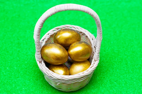 Huevos de oro en una canasta. Para el diseño del tema de Pascua, concepto . — Foto de Stock