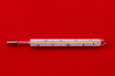 Kırmızı arka planda cıva termometresi. sıcaklık denetimi.