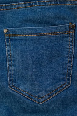 Kot pantolonun cebinde. Kahverengi dikişli mavi kumaş.