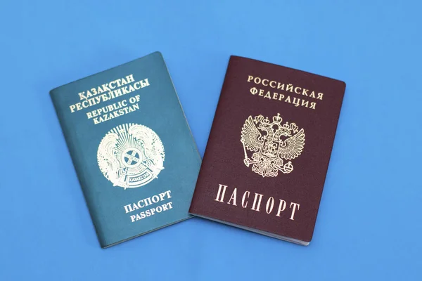 Mavi arka planda Rusya ve Kazakistan pasaportları. Komşu eyaletlerin belgeleri, bir fotoğraf..